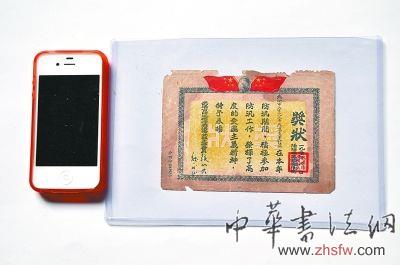 1952年防汛袖珍獎(jiǎng)狀，只比旁邊的蘋果4S手機(jī)大一點(diǎn)。