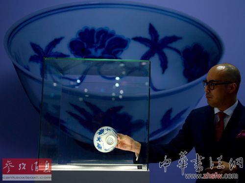 資料圖片：2013年10月8日，蘇富比亞洲區(qū)副主席、中國瓷器及工藝品部國際主管仇國仕將明成化青花宮盌取出。新華社記者 秦晴攝