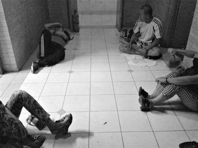 昨日，拍賣公司辦公室大門緊閉空無一人，賣家或坐或躺，在樓道里等待消息。新京報記者 韓萌 攝