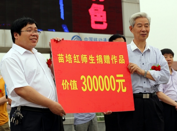 苗培紅(右)為確山靖宇小學(xué)捐贈(zèng)價(jià)值30萬(wàn)元的書(shū)法作品 子玉攝