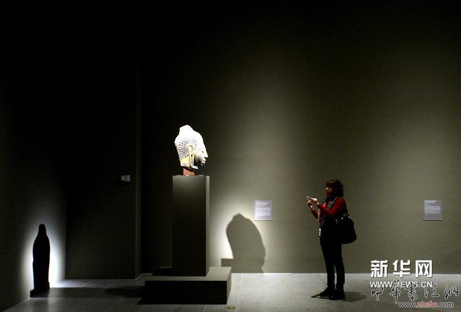 4月7日，一名觀眾在紐約大都會藝術(shù)博物館欣賞來自泰國的印度佛教文物佛頭雕塑，該文物建于公元7世紀(jì)。