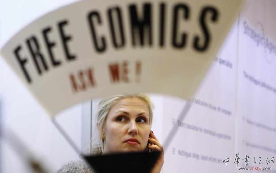 4月8日，在英國倫敦書展上，一位參展商在打電話。