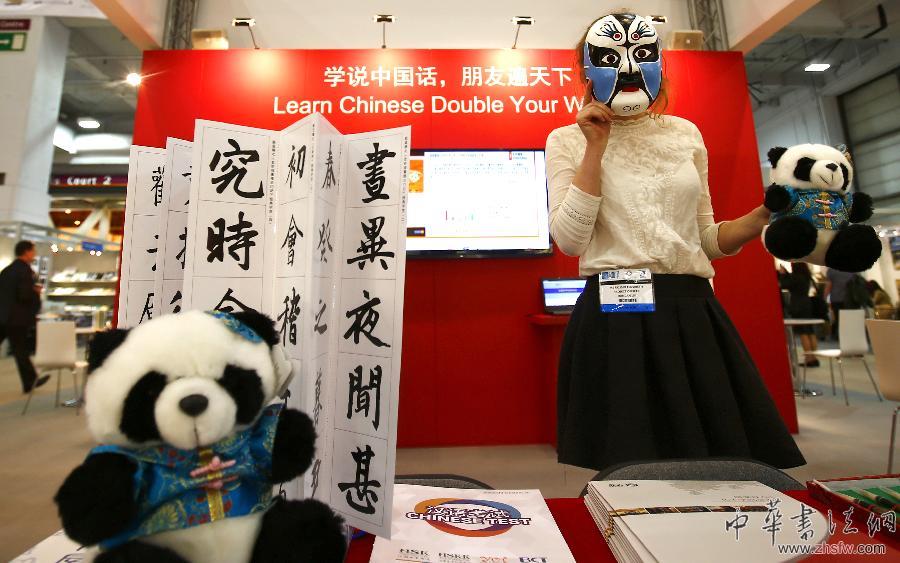 4月8日，在英國倫敦書展上，一位工作人員在中國國家漢辦的展臺戴面具介紹產(chǎn)品。