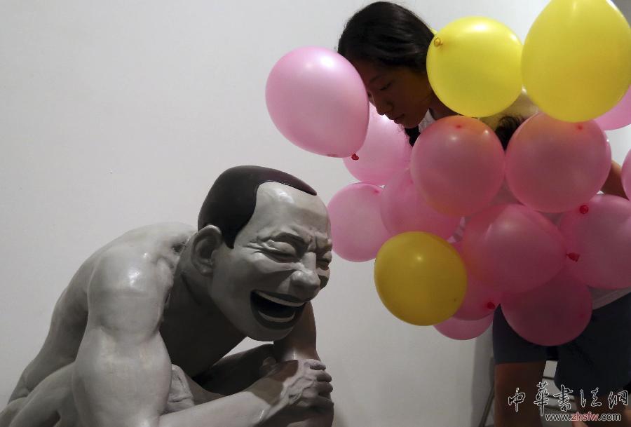 4月8日，南京藝術(shù)學(xué)院環(huán)境編舞專(zhuān)業(yè)的學(xué)生在“大臉畫(huà)——岳敏君新作展”上為觀眾表演“身體的笑容——紅臉人的故事”現(xiàn)代舞。