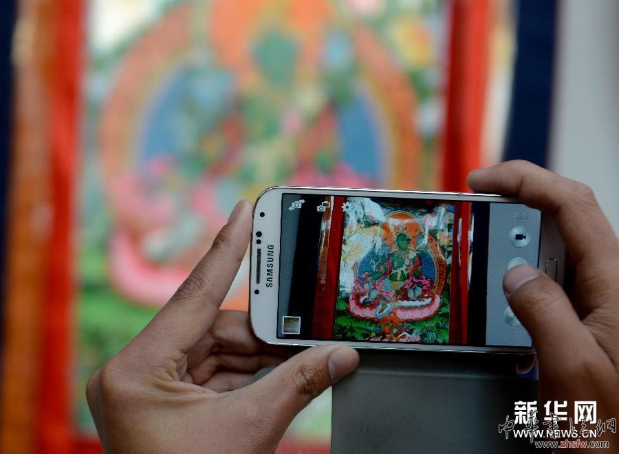 4月10日，一名參觀者在展覽現(xiàn)場(chǎng)拍攝展出作品。