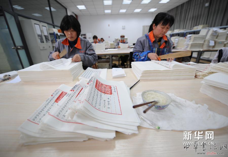 4月16日，裝訂車間工人在對(duì)《四庫全書》書頁進(jìn)行“折頁”操作。