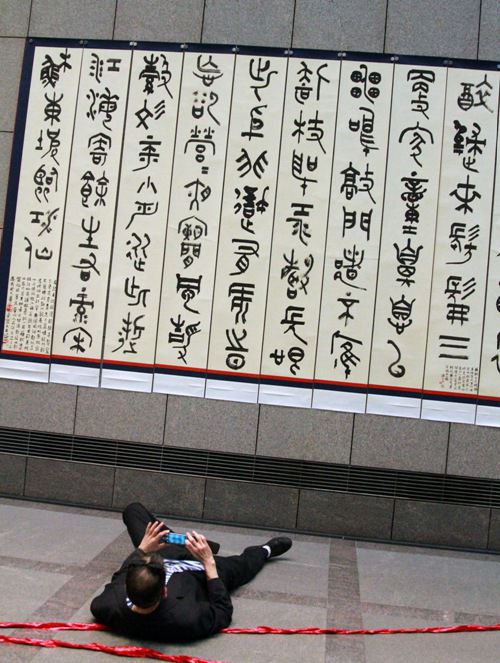 一名觀眾仰躺在地,力圖拍下書法作品的全景。人民網(wǎng)特派記者管克江攝