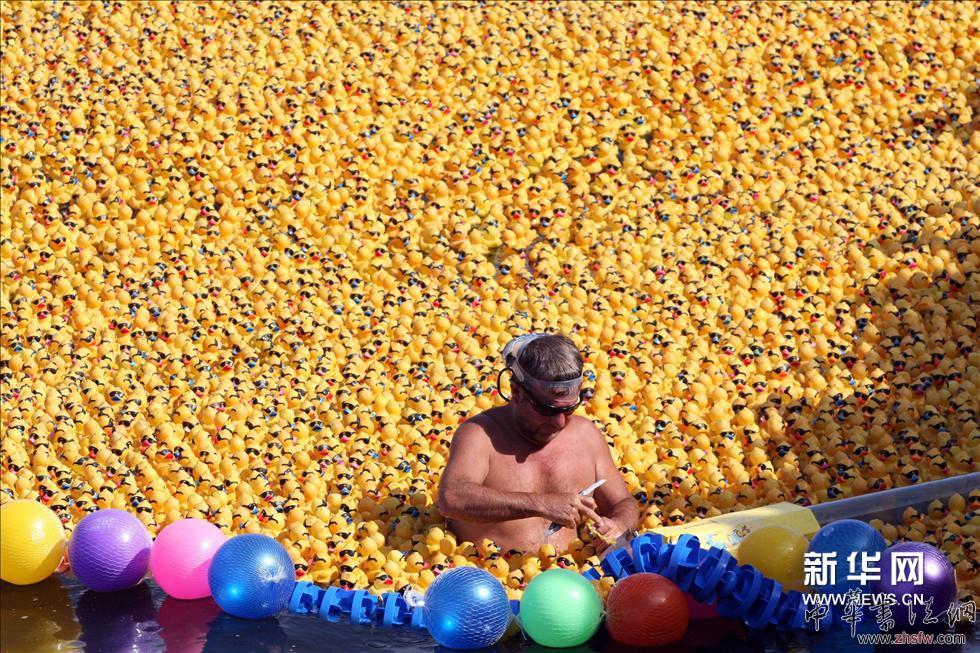 （4）2013年5月12日，在墨西哥坎昆的尼楚普特湖，一名男子在當(dāng)?shù)氐摹按簏S鴨漂流賽”開(kāi)始前檢查12000名“參賽選手”。新華社/法新（張帆編輯）